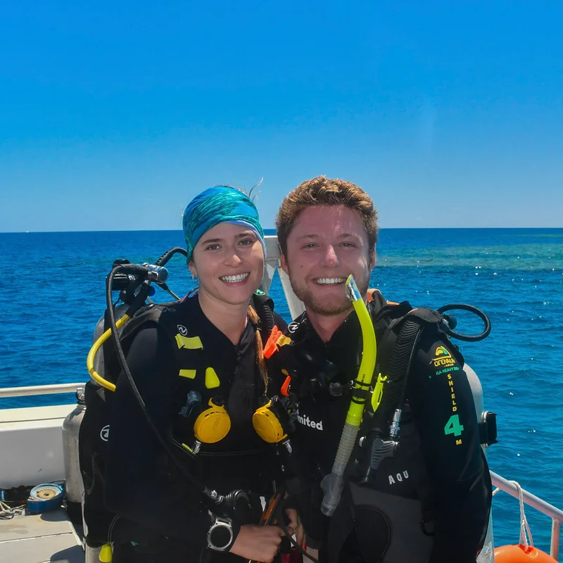 Bex and Oli scuba diving from boat on the Great Barrier Reef